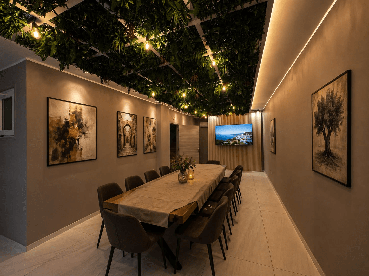 Sala Cavour di Spazio Cavour ad Andria: sala riunioni executive con lungo tavolo in legno per 12 persone, monitor 4K, opere d'arte alle pareti e soffitto vegetale d'atmosfera.